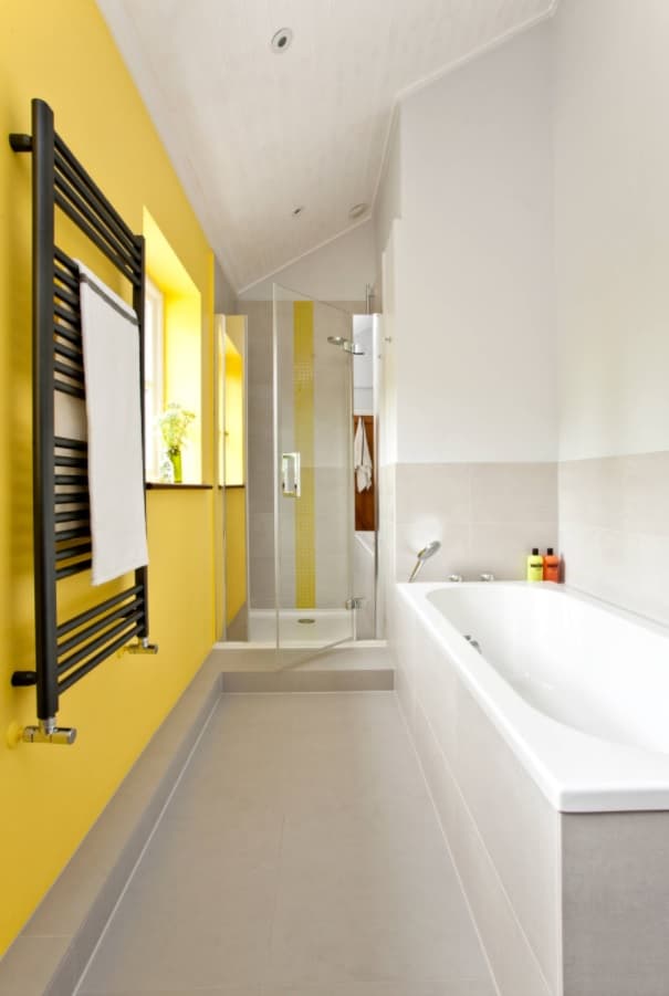 Küçük Bir Banyodan En İyi Şekilde Yararlanmak.  Aksanlı sarı duvar ve siyah duvar ısıtıcısı ile kompakt alanda hoş ve modern tasarım
