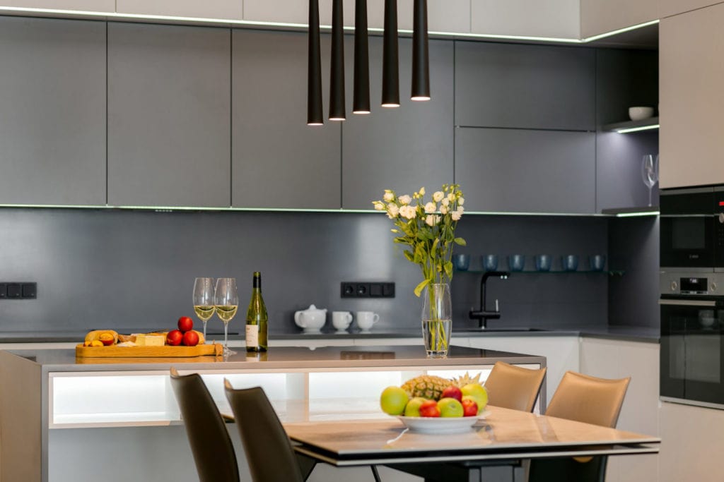 Mutfak Tadilatı Utah'da Mülkünüzün Değerini Nasıl Artırabilir?  Masa ve üzerinde 5 tüp lamba avize ile harika modern tasarımlı mutfak