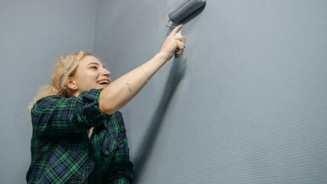 Frau malt die Wand
