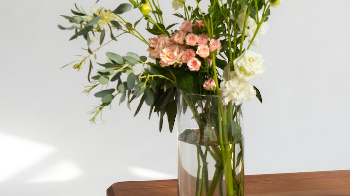 Blumen in Vase auf Holztisch
