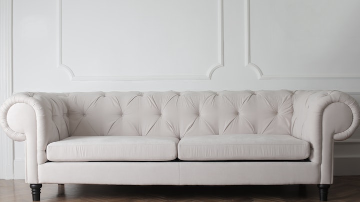sofá de cor clara próximo à parede