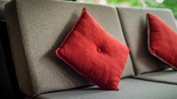 Rotes Kissen auf grauem Sofa